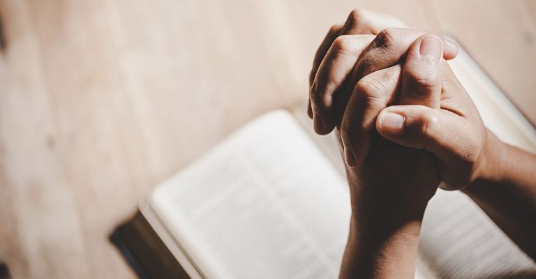 hombre con las manos unidas en oración
